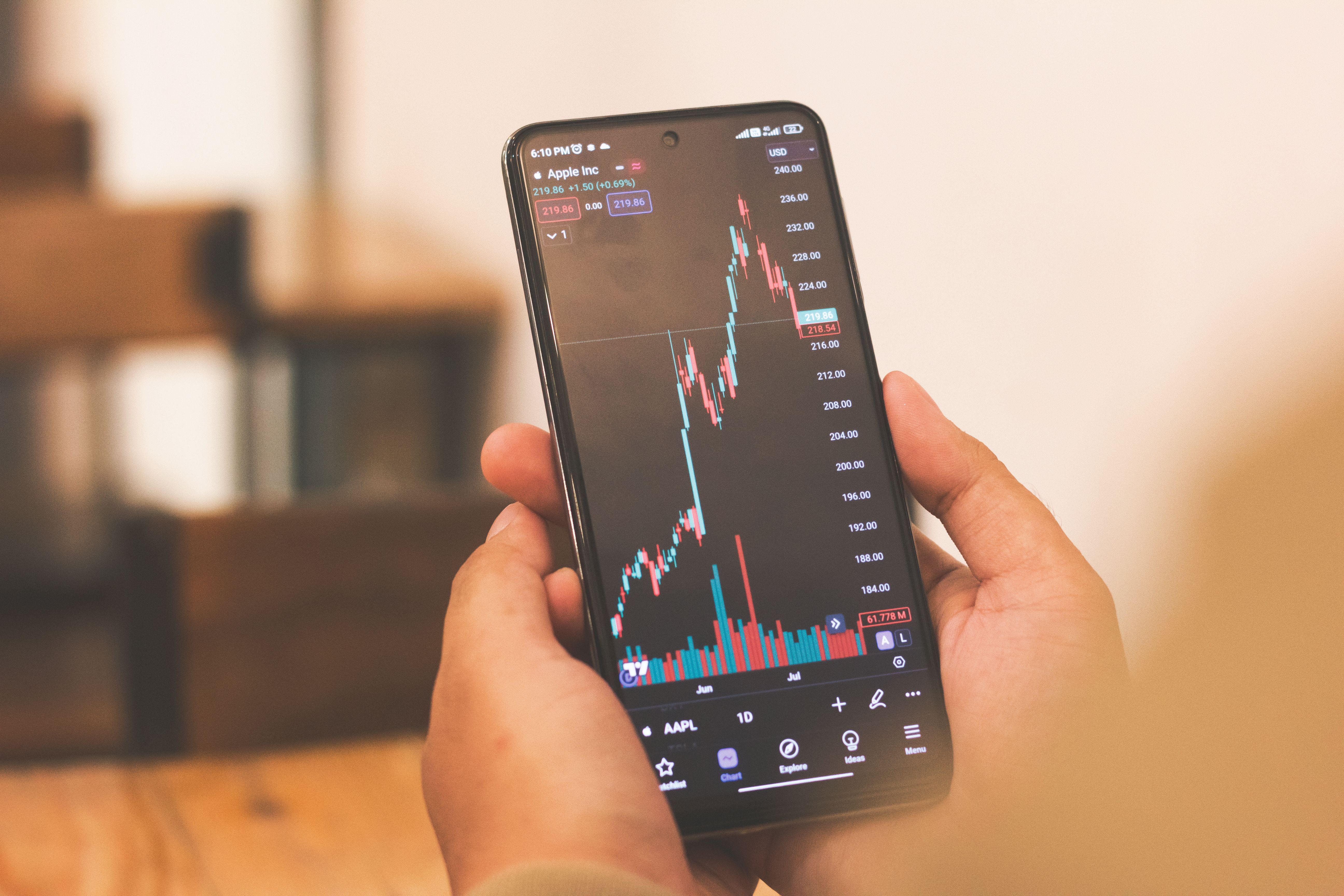 Seseorang melihat grafik harga saham di ponselnya